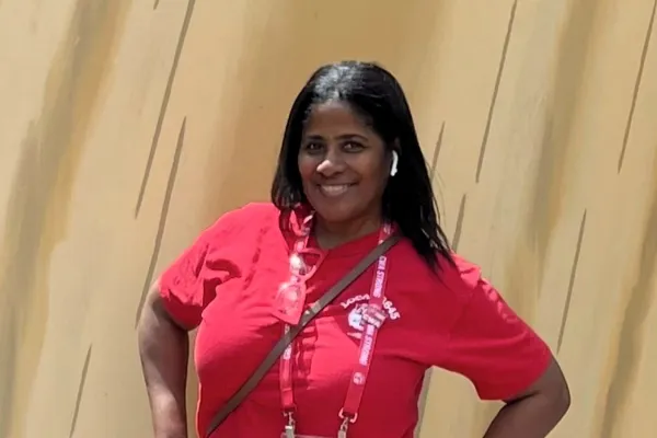 photo of Donielle Prophete wearing a red union t-shirt and blue jeans with her hands on her hips and smiling