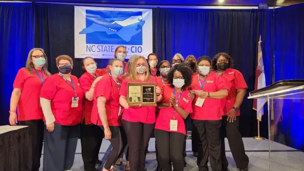 Group photo of nurses holding an award they received for service to the labor movement
